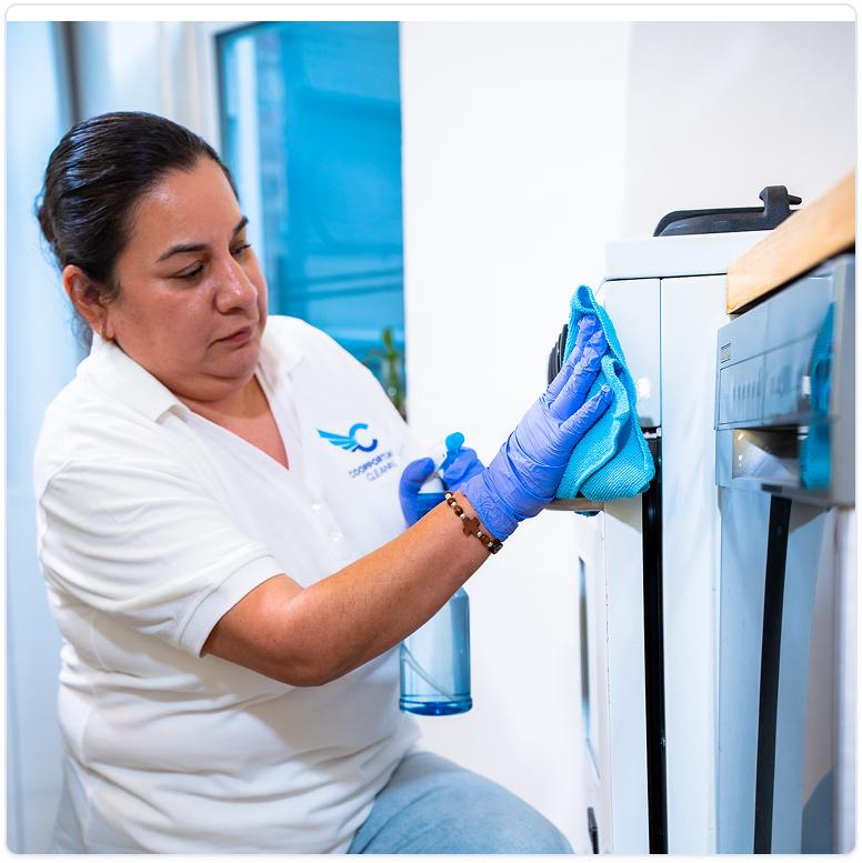 Coopportunity Cleaning professional cleaning the inside of an oven with gloves, delivering detailed cleaning service.